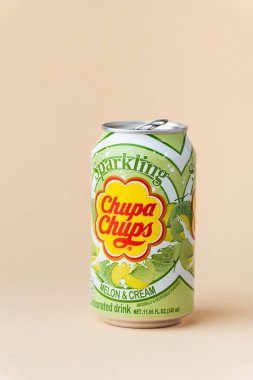 Kyiv, Ukrayna - 24 Mayıs 2025: Chupa Chups alkolsüz köpüksüz kavun aromalı meşrubat bej arka planda bir teneke kutuda. Tropik yaz ferahlatıcı içecek konsepti