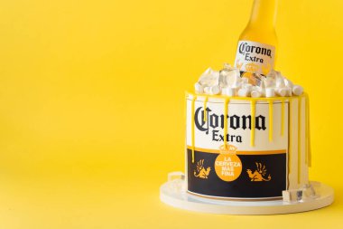 Kyiv, Ukrayna - 28 Eylül 2025: Üstünde bir şişe Corona birası ve yenilebilir buz yığını olan eğlenceli bir pasta. Sarı arka planda bira seven biri için doğum günü pastası.