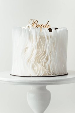 Gelin şeklinde altın kaplamayla süslenmiş güzel beyaz düğün pastası. Beyaz arkaplan