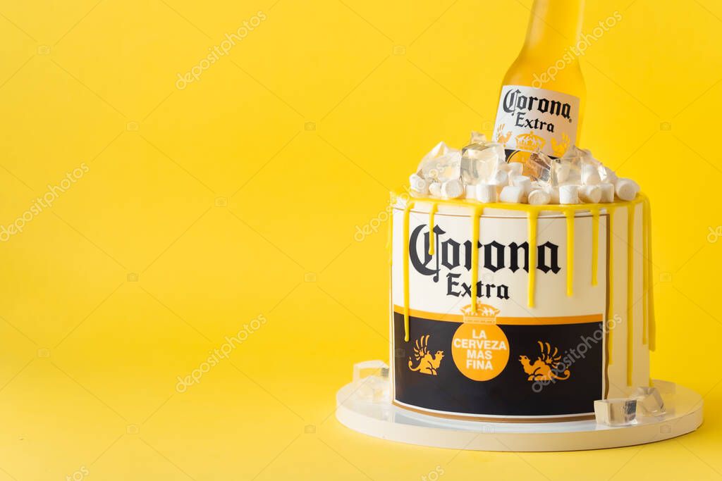Kyiv, Ukraine - September 28, 2025: Fun cake with a bottle of Corona beer in a pile of edible ice on top. Birthday cake for a beer lover on the yellow background