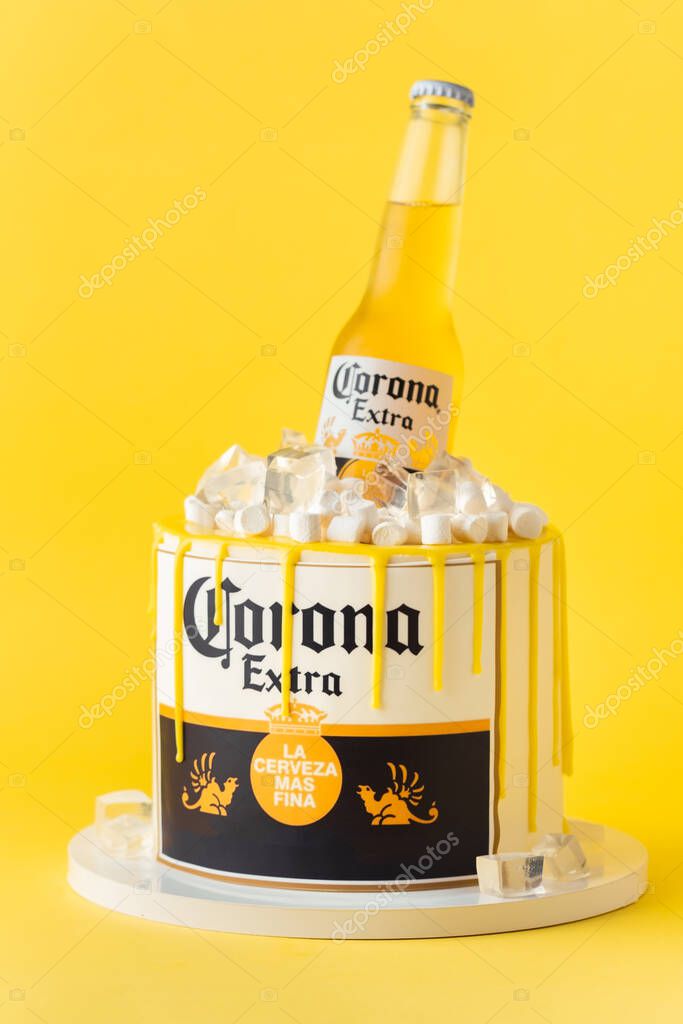 Kyiv, Ukraine - September 28, 2025: Fun cake with a bottle of Corona beer in a pile of edible ice on top. Birthday cake for a beer lover on the yellow background