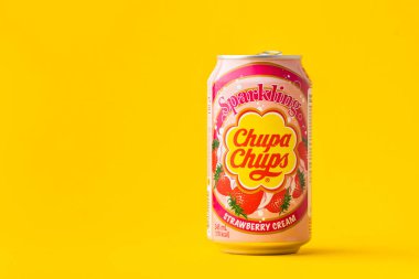 Kyiv, Ukrayna - 19 Temmuz 2025: Chupa Chups, sarı arka plandaki teneke kutuda alkolsüz köpüklü çilek aromalı meşrubat. Tropik yaz ferahlatıcı içecek konsepti