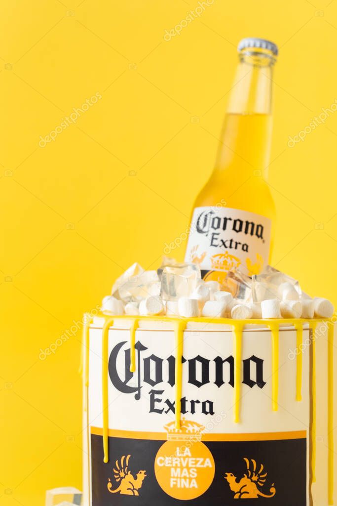 Kyiv, Ukraine - September 28, 2025: Fun cake with a bottle of Corona beer in a pile of edible ice on top. Birthday cake for a beer lover on the yellow background
