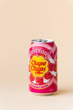 Kyiv, Ukrayna - 24 Mayıs 2025: Chupa Chups alkolsüz köpüksüz ahududu aromalı meşrubat bej arka planda bir teneke kutuda. Tropik yaz ferahlatıcı içecek konsepti