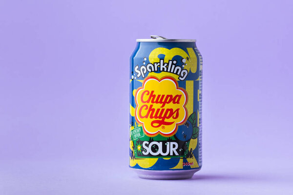 Киев, Украина - 19 июля 2025 года: безалкогольный игристый безалкогольный безалкогольный напиток Chupa Chups со вкусом черники в банке на фиолетовом фоне. Тропическая концепция летнего освежающего напитка