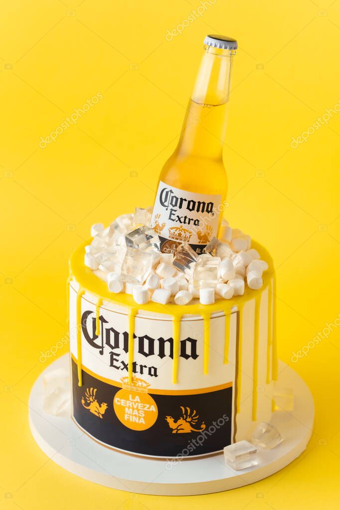 Kyiv, Ukraine - September 28, 2025: Fun cake with a bottle of Corona beer in a pile of edible ice on top. Birthday cake for a beer lover on the yellow background