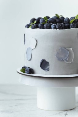 Üzerinde bir sürü yaban mersini olan gri krem peynirli tatlı pasta. Gri arkaplan