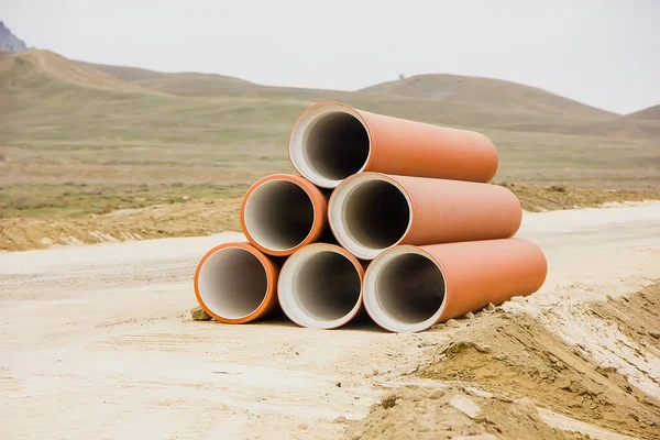 Yolun kenarındaki geniş çaplı borular, dağların arka planına karşı. yakın plan