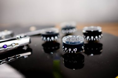 Ses düğmelerine vurgu yapan siyah elektro gitar..