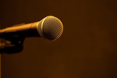 İzole edilmiş mikrofon, bir kaidede, siyah bir arkaplanda..