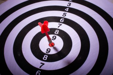 Siyah ve beyaz hedefin ortasına kırmızı ok saplanmış. Seçici odak.