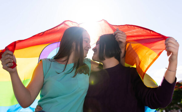 Девушки-лесбиянки развлекаются тем, что рисуют себя и с флагом ЛГБТ на гордости.