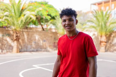 Afrikalı Amerikalı çocuk sokakta kameraya bakıyor.