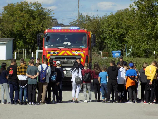 Çocuklar itfaiye aracının yanında.