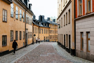 Stockholm 'de Sodermalm' de renkli evleri olan resimli kaldırımlı bir cadde.