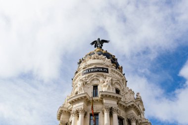 Madrid 'deki ünlü Metropolis Binası' nın ikonik manzarası. Mavi gökyüzüne karşı güneşli bir gün