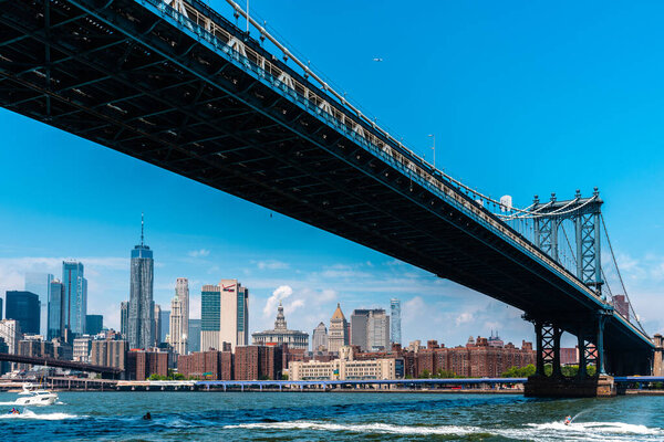 New York City, USA - June 24, 2018: Manhattan Bridge and cityscape from East River. Iconic view of NYC