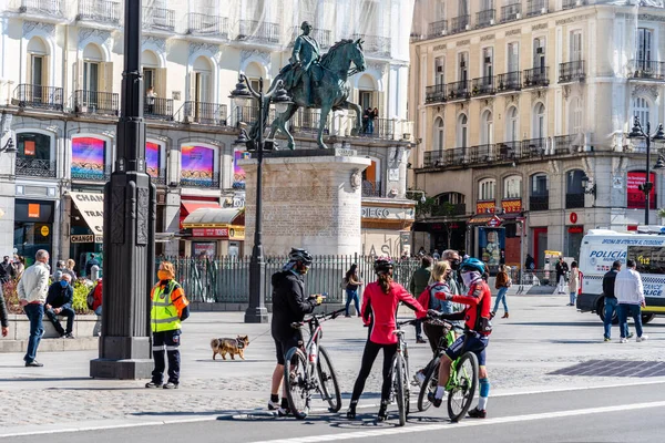Ciclistas de pie en la Plaza Puerta del Sol en el centro de Madrid —  Fotos de Stock