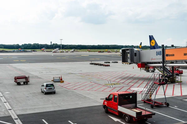 Vehículos comerciales y dedo para pasajeros en la pista del aeropuerto — Foto de Stock