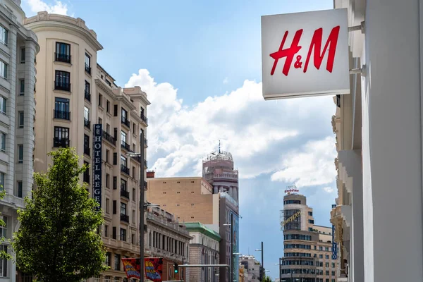 H and M fashion store sign in Gran Via against cityscape in Madrid — Stockfoto