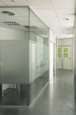 Empty meeting room and corridor  with glass walls in a modern office building clipart