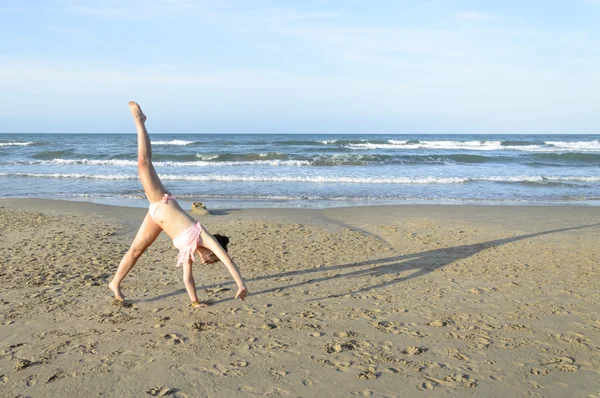 女の子がビーチで腕立て側転 — ストック写真