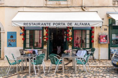 Lizbon, Portekiz - 29 Ekim 2022: Lizbon, Portekiz 'in tarihi Alfama bölgesinde açık hava oturma ve geleneksel dekorasyonlu büyüleyici bir restoran.