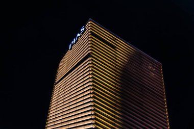 Tokyo, Japonya - 5 Ağustos 2024: Tokyo 'nun Ginza ilçesinde gece gökyüzüne karşı yatay çizgileri olan modern bir bina parlıyor. Mimari aydınlık yüzüyle çarpıcı..