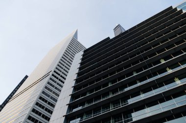 Chicago şehir merkezindeki modern bir gökdelenin alçak açılı görüntüsü mimari detaylar ve açık bir gökyüzü sergiliyor. Bu görüntü şehir manzarasını yakalar..