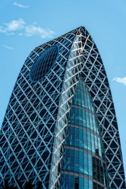 Tokyo, Japonya - 4 Ağustos 2024: Tokyo 'nun çarpıcı bir simgesi olan Mode Gakuen Koza Kulesi, genişleyen kentsel manzaranın ortasında duruyor.