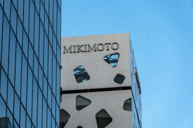 Tokyo, Japonya - 3 Ağustos 2024: Tokyo, Japonya 'nın Ginza bölgesinde bulunan Mikimoto binası açık mavi gökyüzüne karşı modern mimari sergilenmektedir..