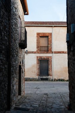 Medinaceli, Soria. Çakıl taşı caddesi boyunca terracotta çatı kiremitleri olan geleneksel taş ev. Ortaçağ köyü