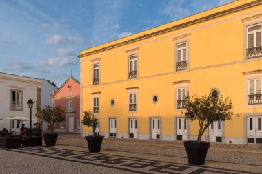 Cascais, Portekiz - 30 Ekim 2022: Portekiz 'in Cascais Kalesi' ndeki bir otelin dış görünüşü, sarı duvarlar ve kaldırım taşlı bir patika içeriyor..