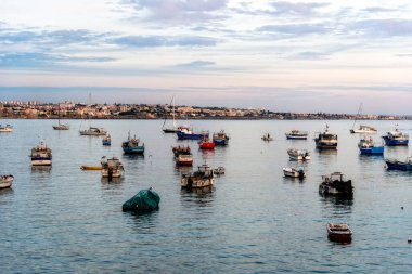 Cascais, Portekiz - 30 Ekim 2022: Cascais, Portekiz 'in sakin sularında yüzen çeşitli teknelerin manzarası, gün batımında manzara.