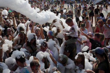 Odessa, Ukrayna 7 Ağustos 2021 Köpük makinesinden bir grup çocuk köpük partisinde eğleniyor ve dans ediyor