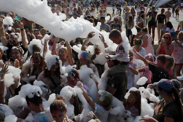 Odessa, Ukrayna 7 Ağustos 2021 Köpük makinesinden bir grup çocuk köpük partisinde eğleniyor ve dans ediyor