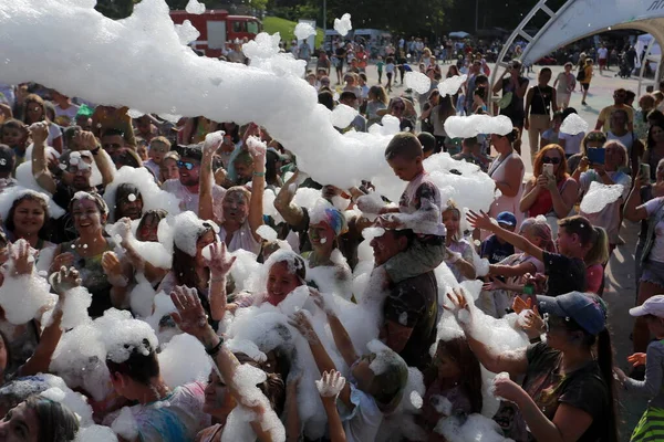 Odessa, Ukrayna 7 Ağustos 2021 Köpük makinesinden bir grup çocuk köpük partisinde eğleniyor ve dans ediyor