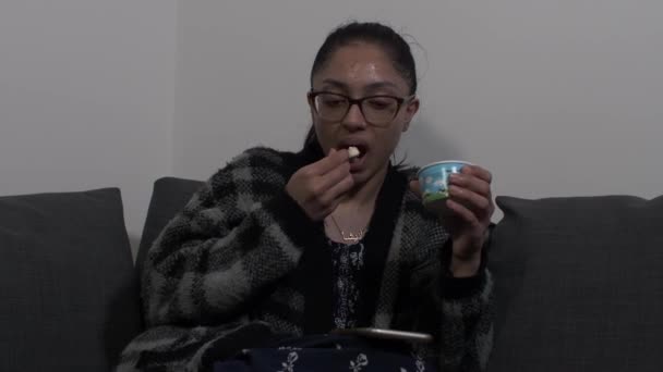 Young Woman Eating Ice Cream Couch Whilst Browsing Mobile Phone — Stock Video