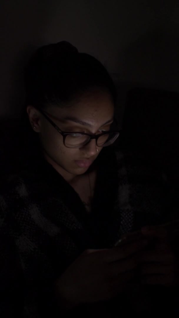 女性戴眼镜观看夜间流动电话的景观 垂直视频 锁定关闭 — 图库视频影像