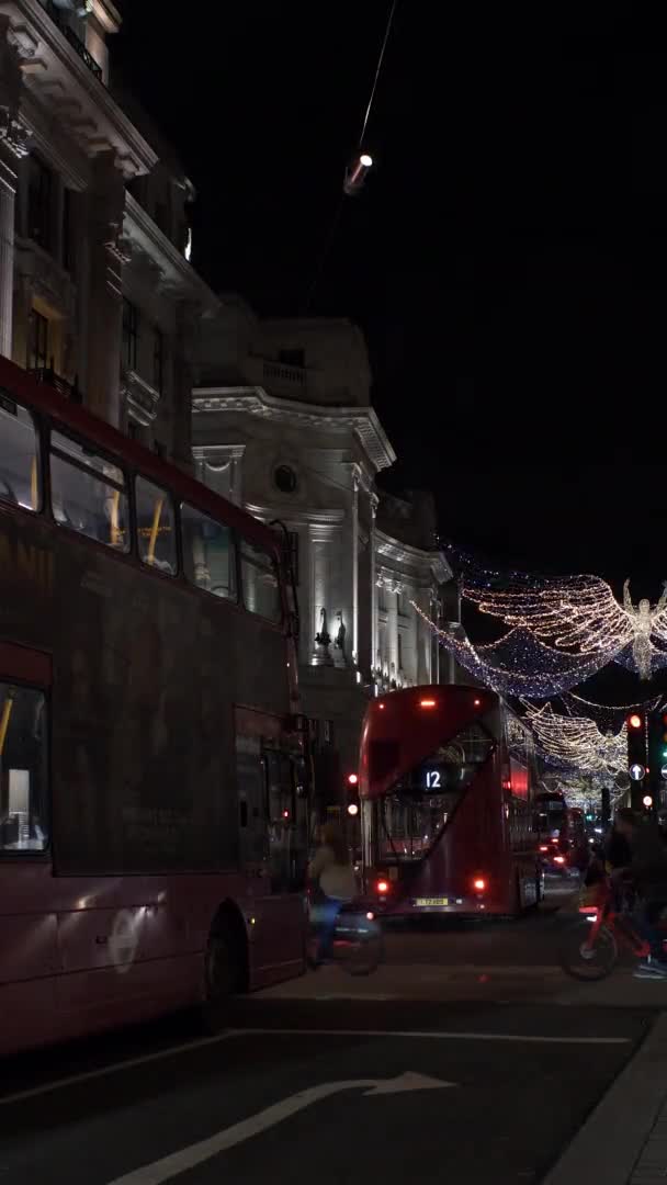 夜間のロックダウン中にクリスマスライト付きのリージェントストリートのバス 垂直ビデオ ロックオフ — ストック動画