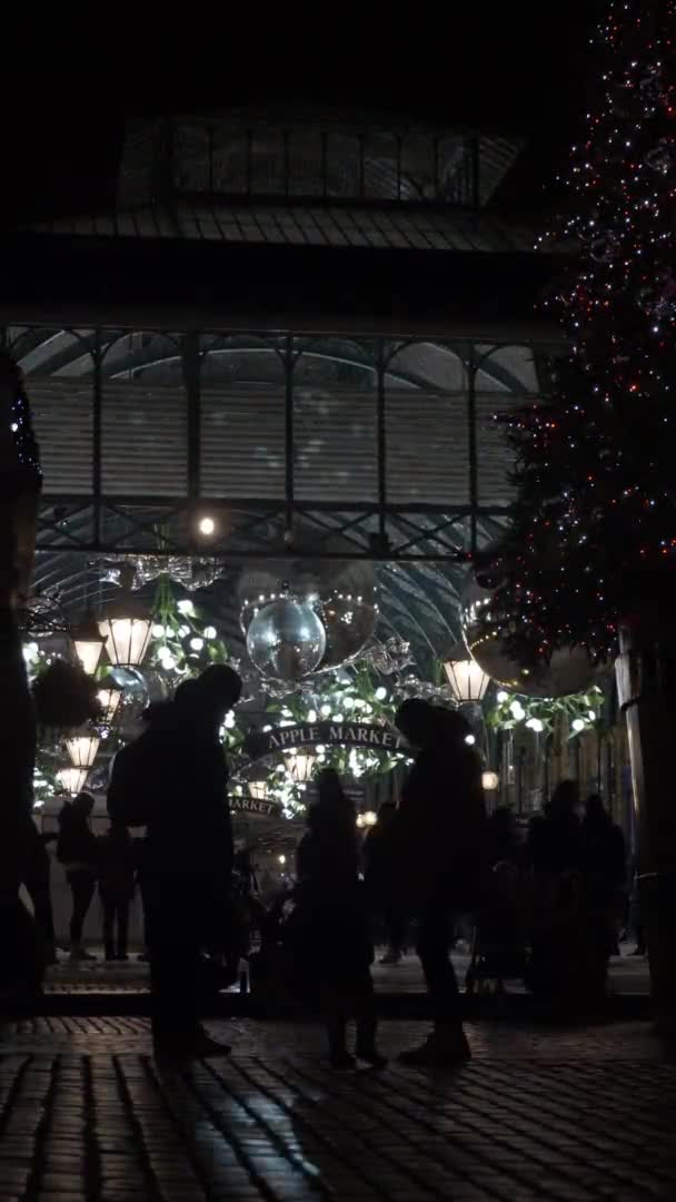 游客在夜间关闭时走过科文特花园广场 垂直视频 低角度 锁定关闭 — 图库视频影像