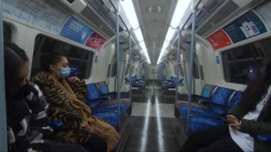 Yıldönümü treninde oturan üç kadın yüz maskeleri ve sosyal mesafeler takıyorlar.