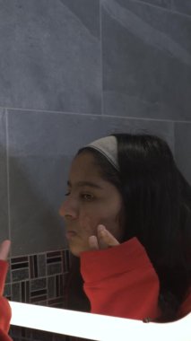 Genç İngiliz Asyalı Kadın Genç Banyodaki Sivilce Aynası Kontrol Ediyor. Dikey Video, Kilitli 