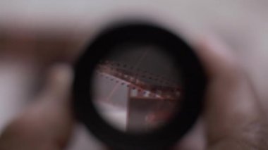 POV, 35 mm Fotoğraf Negatifleri 'nde Loupe büyüteçine bakıyor. Kapat, Kapalı