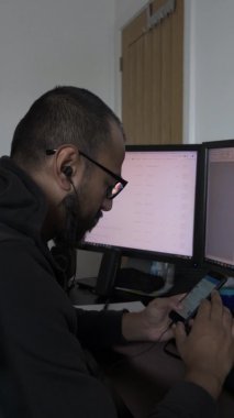 İngiliz Asyalı, gözlüklü, evde çalışırken telefondan kayan. Dikey Video, Kilitli