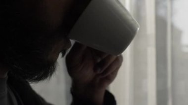 Sakallı, Kupadan İçen Erkek Perdelerin Yakınına Bakıyor. Kapat, Kapalı