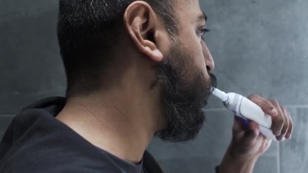 Ethnische Minderheit Erwachsener Mann Mit Elektrischer Zahnbürste Seitenansicht Abgesperrt — Stockvideo