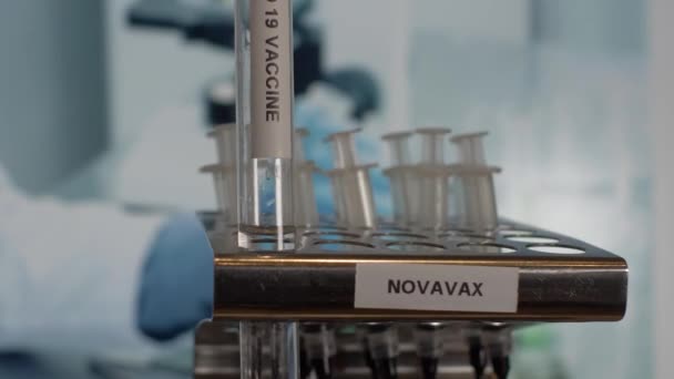 Novavax Covidワクチン試験管バイアルをラックに入れます 閉鎖しろ閉鎖しろ — ストック動画
