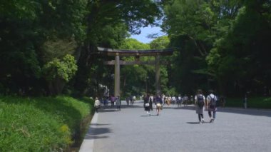 Meiji Jingu Tapınağı 'nın girişini simgeleyen Büyük Torii Kapısı' ndan geçen turistler. Kilitli 
