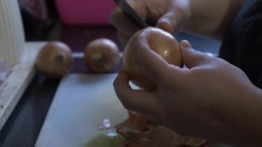 Mutfakta soğan soymak için bıçak kullanan kadın ellerine yakın çekim. Kilitli